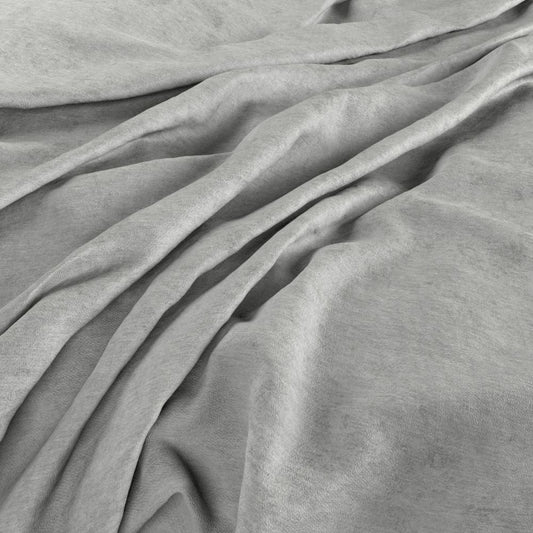 Draped Aurea Chenille Feather Grey fabric showcasing its soft, washable texture and elegant grey hue, perfect for upholstery and décor.