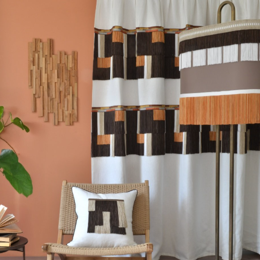 Curtain and lampshade with geometric fringe trim pattern in a lounge setting