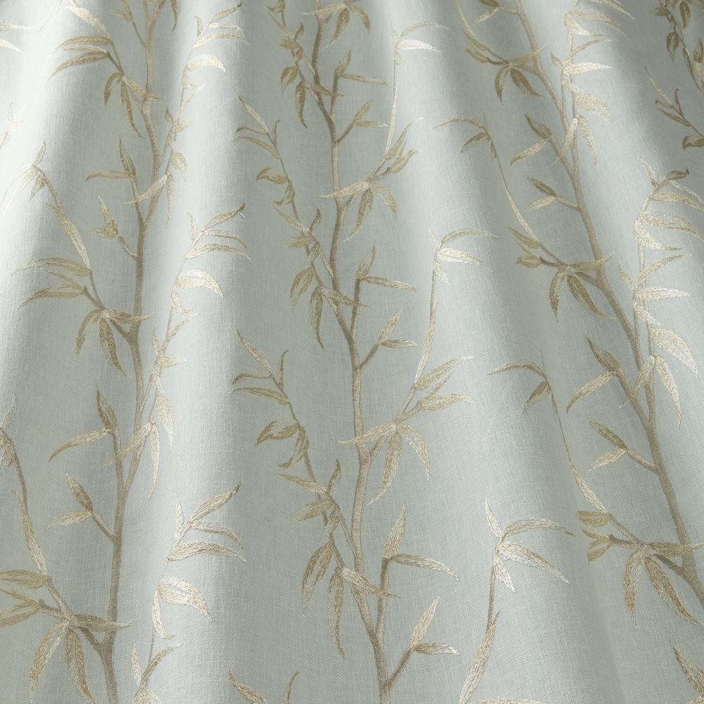 Close-up of Sakura Bamboo Duck-Egg fabric showcasing intricate bamboo leaf embroidery on a light blue cotton base for elegant interiors.