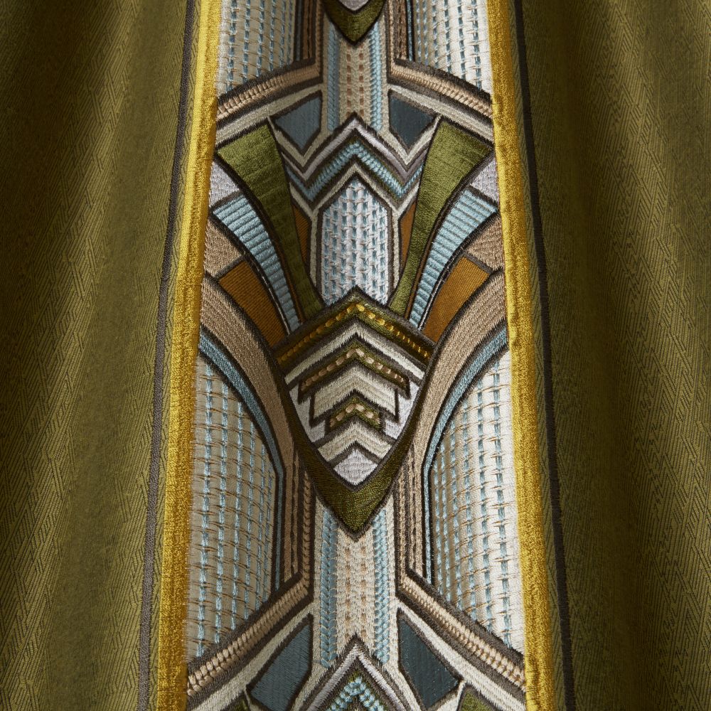 Close-up of Chrysler Art Deco Moss fabric highlighting detailed geometric embroidery in green, blue, and gold on a velvet base.