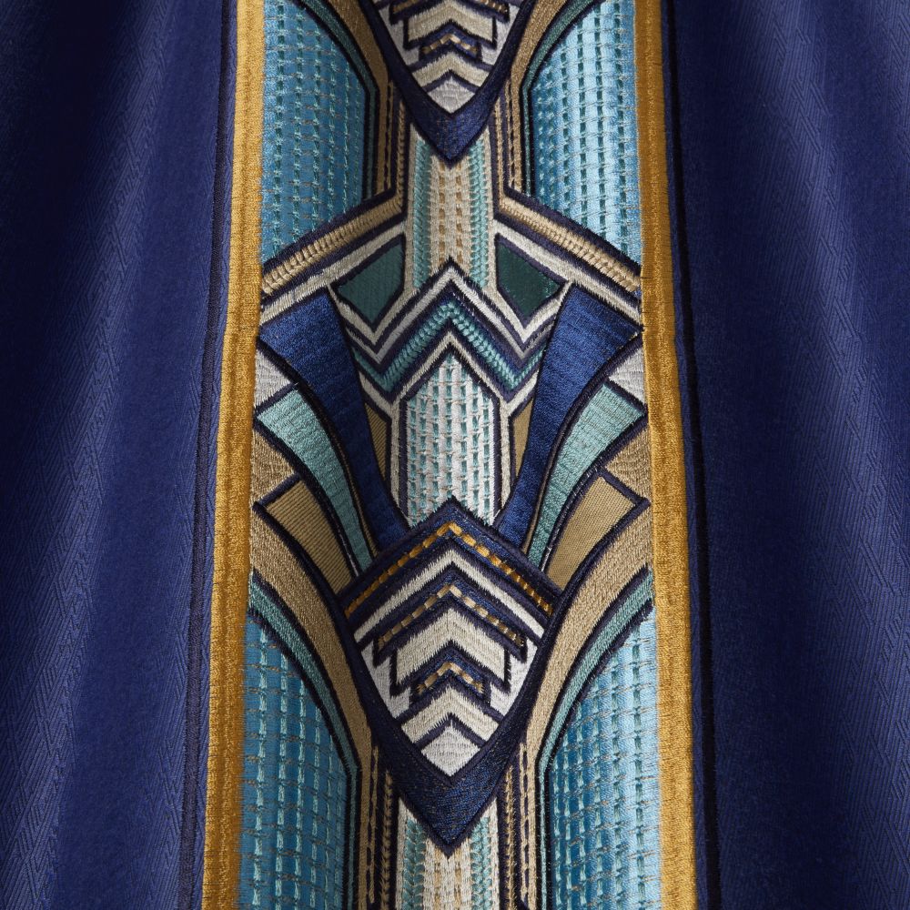 Close-up of Chrysler Art Deco Sapphire fabric showcasing detailed embroidery with geometric patterns in vibrant blue, teal, and gold hues.