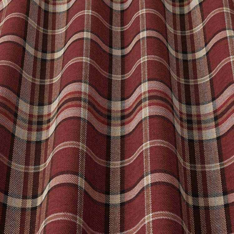Close-up of Glenmore Contract Check Sangria tartan fabric with a flowing texture, showcasing its red and beige plaid design. Perfect for upholstery and decor.