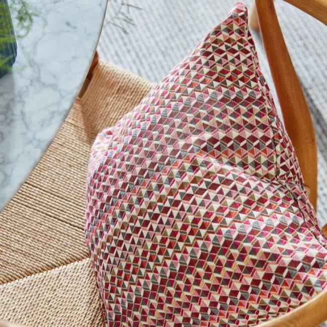 Decorative cushion made from Motley Woven Geometric Flamenco fabric, showcasing its textured 3D geometric design for stylish home décor.