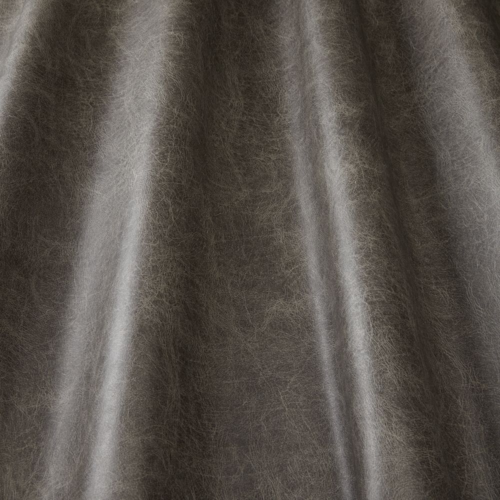 Close-up of Pommel Contract Mocha vinyl draped to showcase its soft, leather-like texture and rich brown tone for upholstery use.