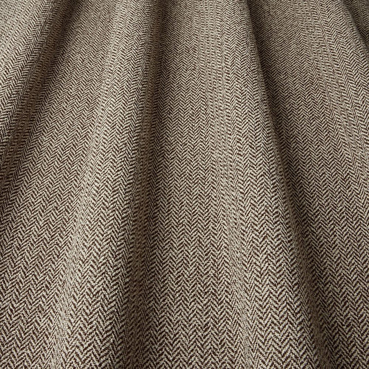 Close-up of herringbone patterned fabric in brown and beige.