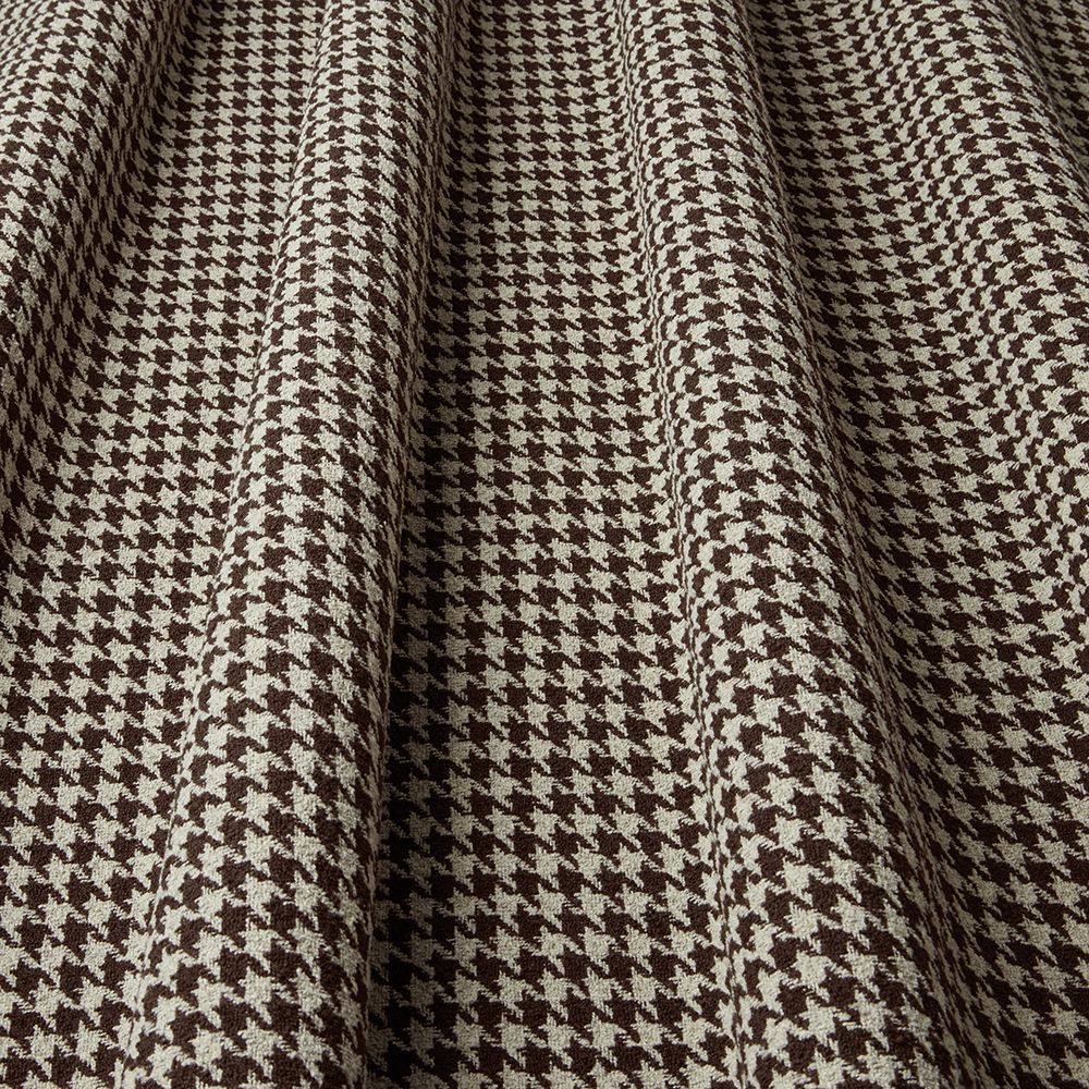 Close-up of houndstooth pattern fabric with brown and beige colors.