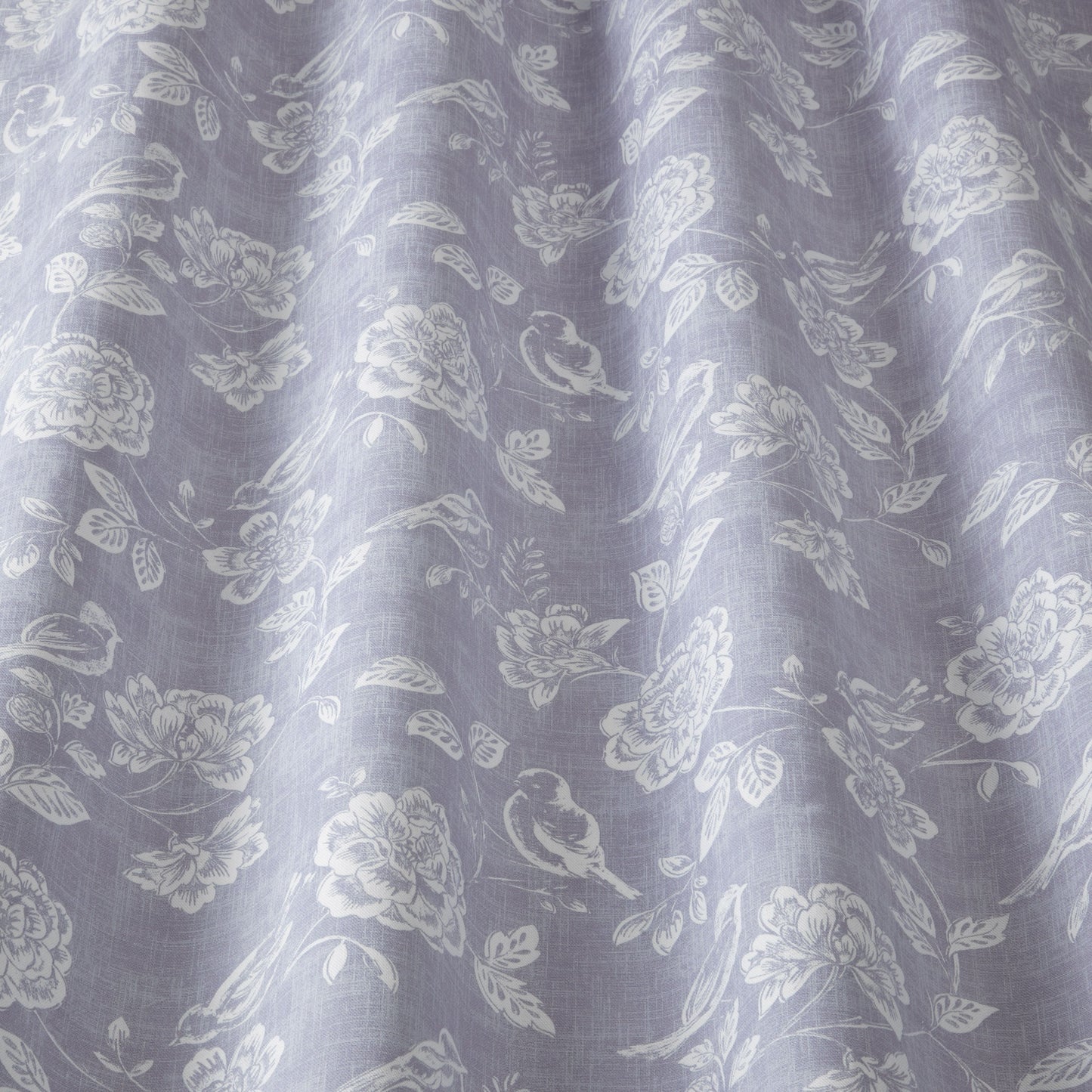Close-up of Sparrow Bloom Lavender fabric with intricate floral and bird patterns in white, highlighting its texture and soft lavender hue.