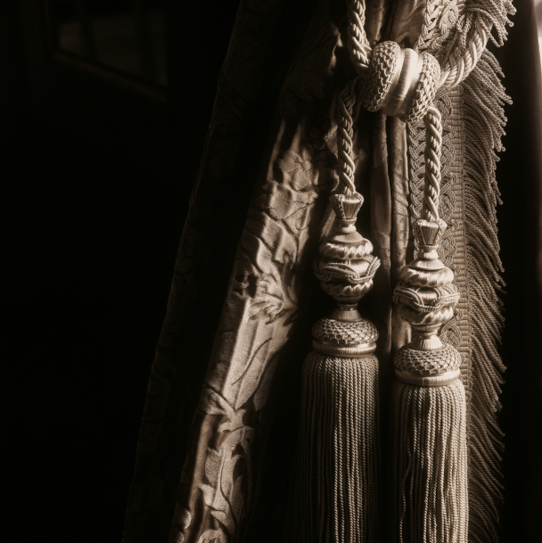 Close-up of decorative curtain with tassels on a dark background