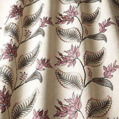 Close-up of Climbing Fruitlet Thistle fabric highlighting detailed purple floral embroidery and green leaves on a beige textile for crafting projects.