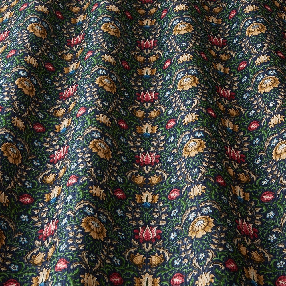 Close-up of Garnett Jewel cotton fabric showcasing detailed floral designs in red, yellow, and green, perfect for arts and crafts projects.