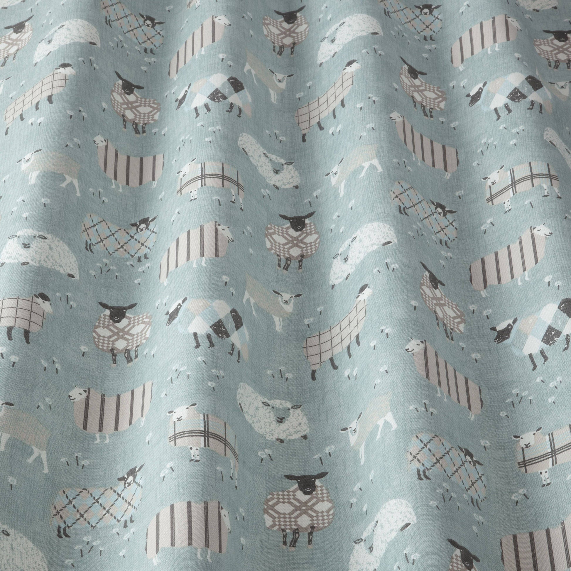 Close-up of Grazing Pastures Duck Egg fabric with cartoon sheep design, suitable for kids’ curtains, blinds, or upholstery projects.