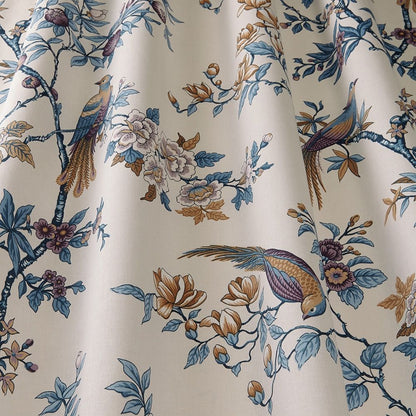 Close-up of Sakura Kyoto Dusty Blue cotton fabric showcasing intricate blooming flowers and birds in blue and gold tones, perfect for home décor.