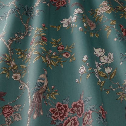 Close-up of Sakura Kyoto Emerald fabric showcasing detailed blooming flowers and perched birds on a green background.