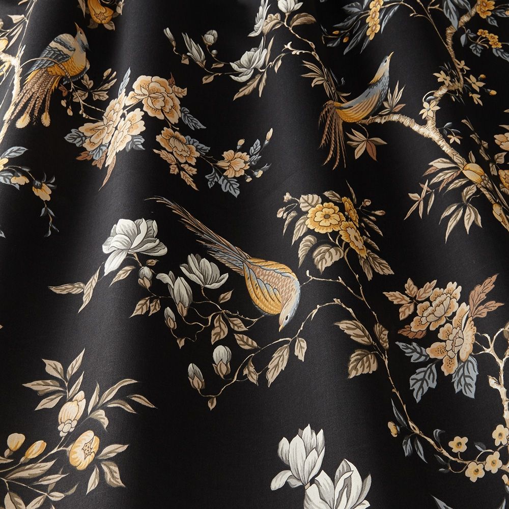 Close-up of Sakura Kyoto Obsidian fabric showcasing detailed blooming flowers and perched birds on a black cotton base for home décor.