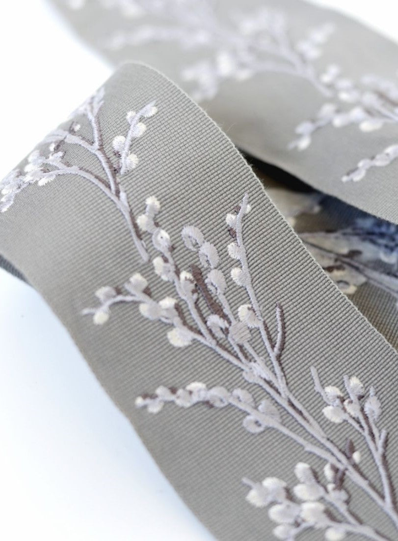 Elegant Laura Ashley Border Pussy Willow Steel trim featuring delicate white floral embroidery on a soft gray fabric, ideal for curtains.