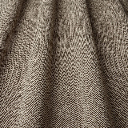 Close-up of herringbone patterned fabric in brown and beige.