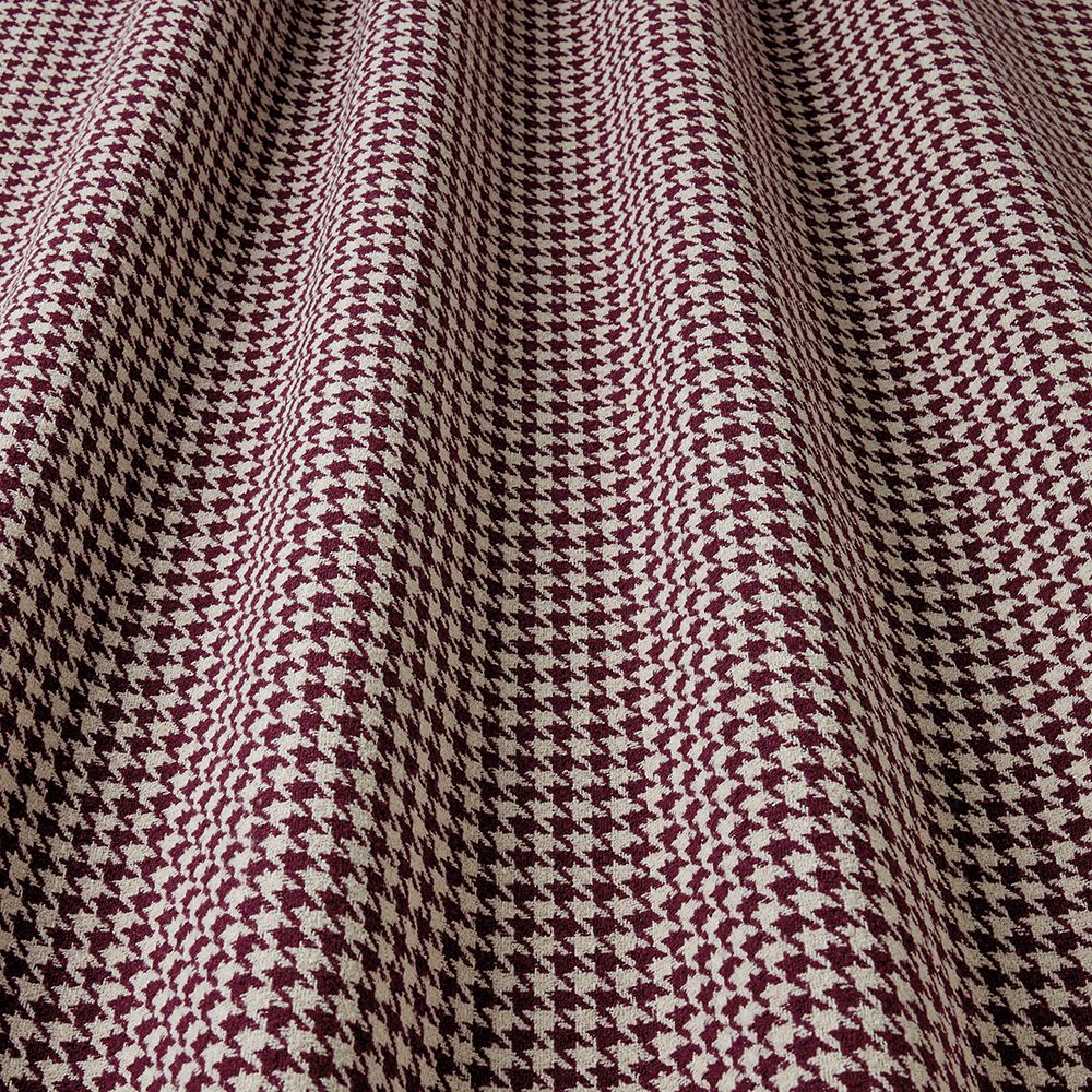 Close-up of houndstooth pattern fabric with maroon and beige colours.