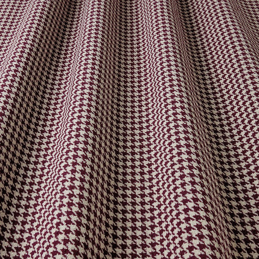 Close-up of houndstooth pattern fabric with maroon and beige colours.