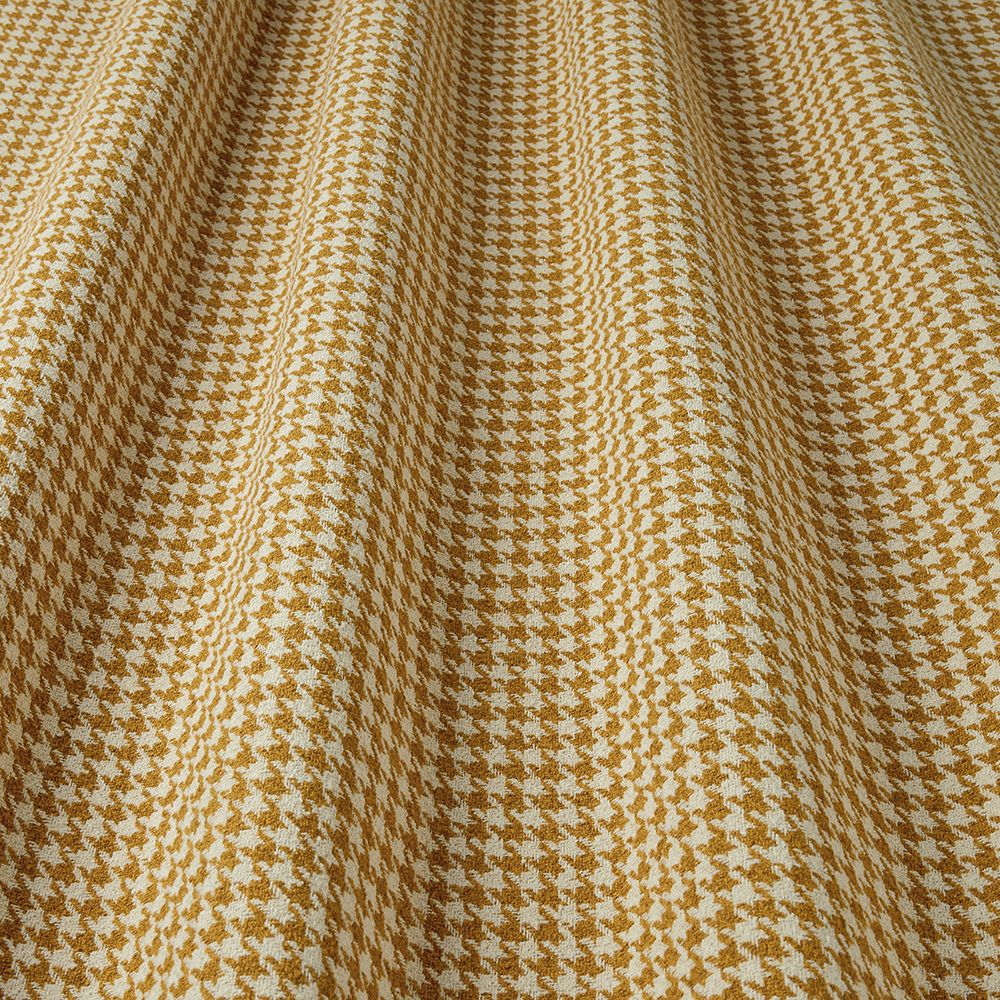 Close-up of houndstooth pattern fabric with gold and white colours.