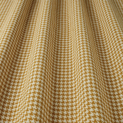 Close-up of houndstooth pattern fabric with gold and white colours.