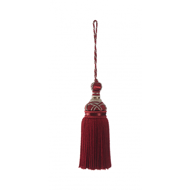 Red key tassel with decorative top on a white background