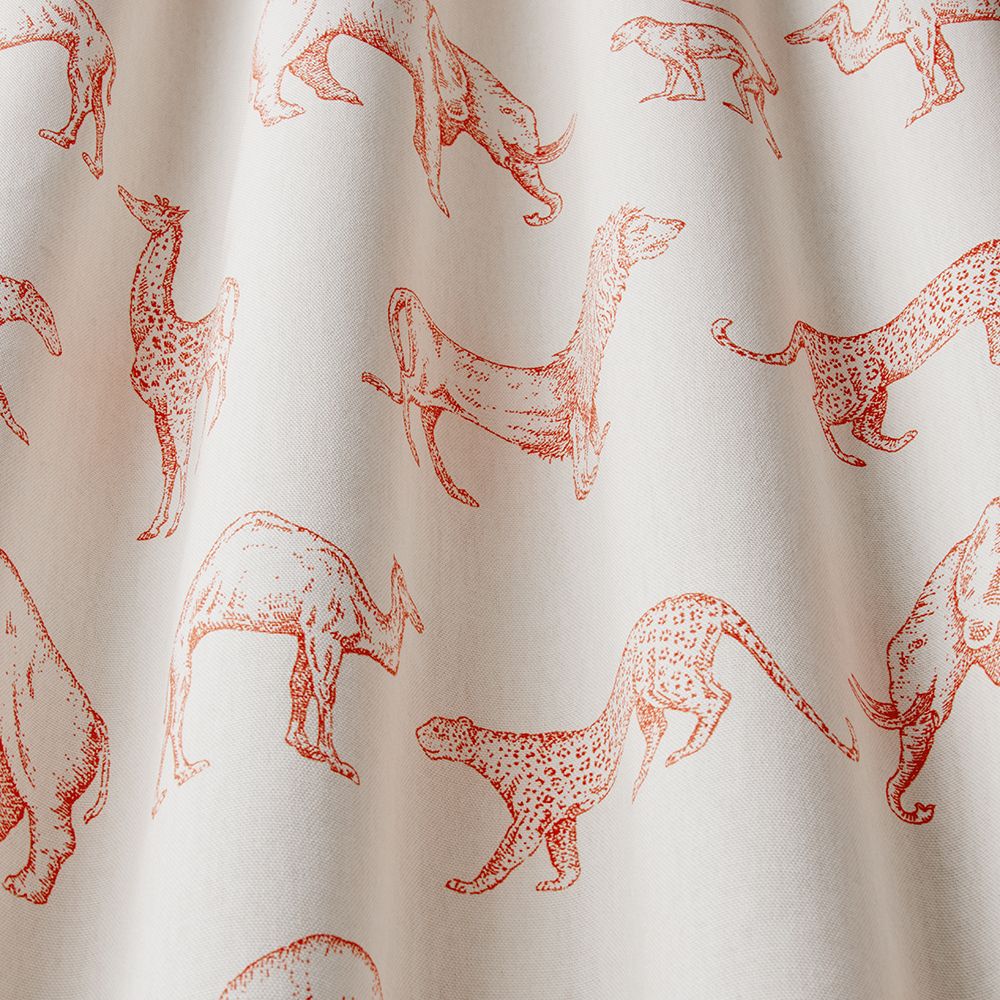 Close-up of African Safari Tangerine fabric showcasing detailed orange hand-drawn animals on soft beige cotton material.