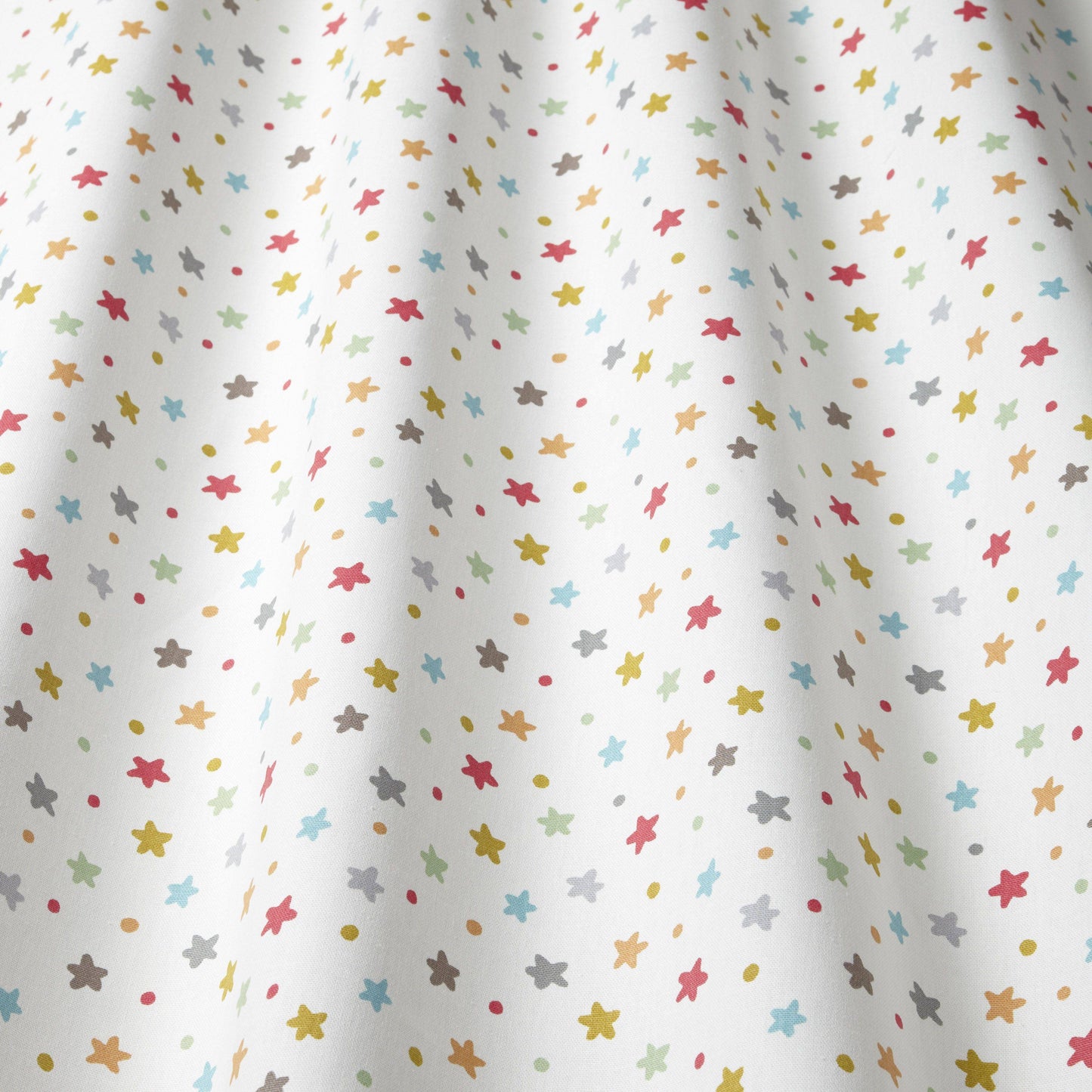 Close-up of Starburst Multi cotton fabric with colourful star pattern, great for children's curtains, blinds, and upholstery in creative spaces.