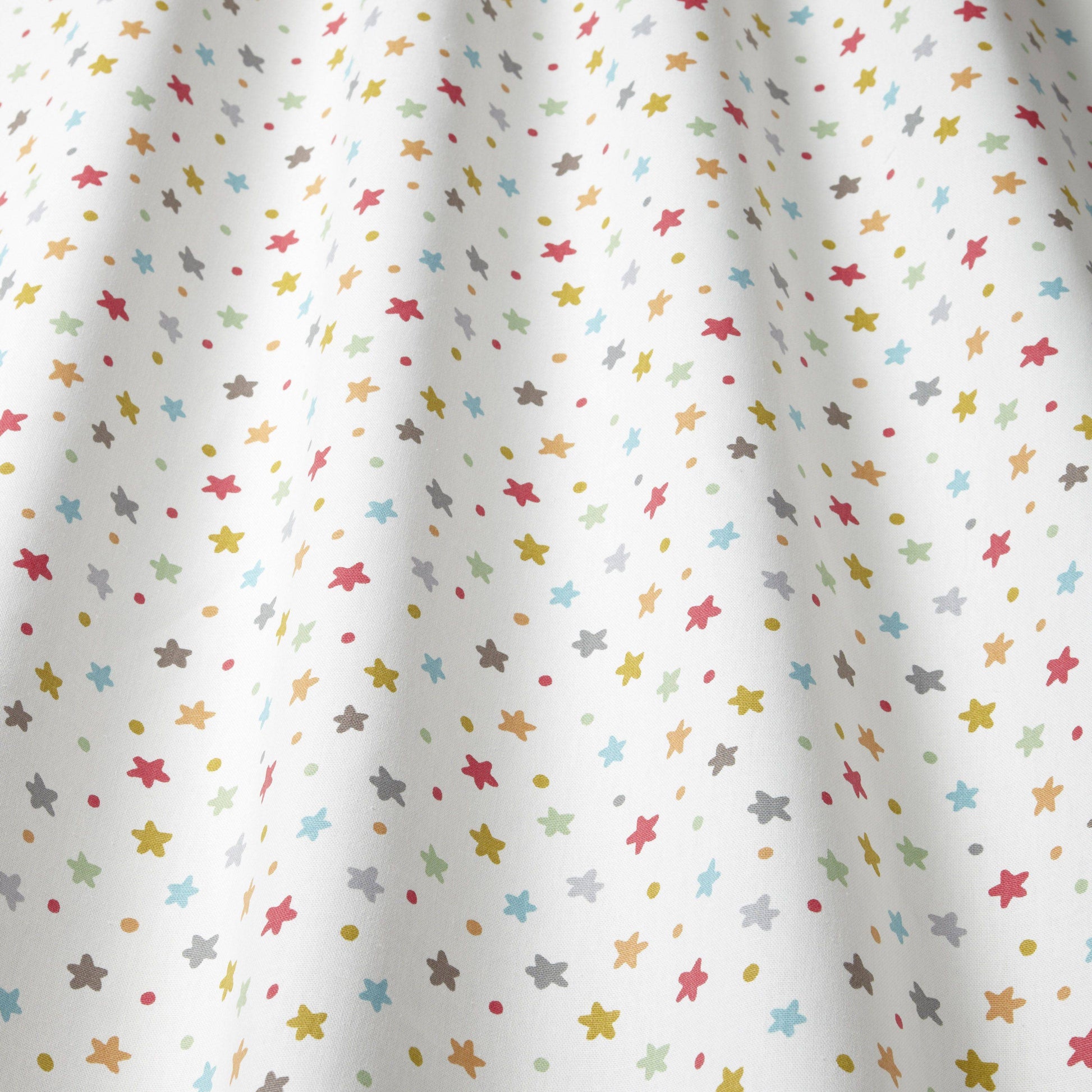 Close-up of Starburst Multi cotton fabric with colourful star pattern, great for children's curtains, blinds, and upholstery in creative spaces.