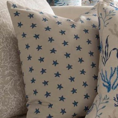 Decorative cushion made with Stellaria Polka Natural fabric featuring blue starfish print, perfect for children's room upholstery or coastal interiors.