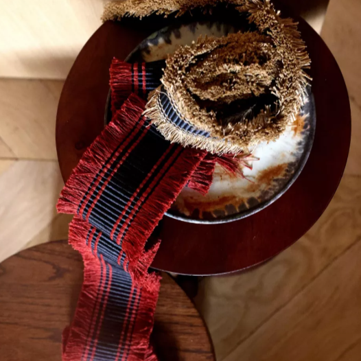 Decorative plate with a red braid on a wooden surface