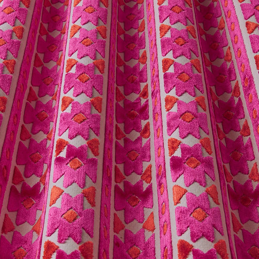 Zanzibar Velvet Fuchsia fabric with bold geometric patterns in vibrant pink and orange tones, ideal for upholstery and drapery projects.