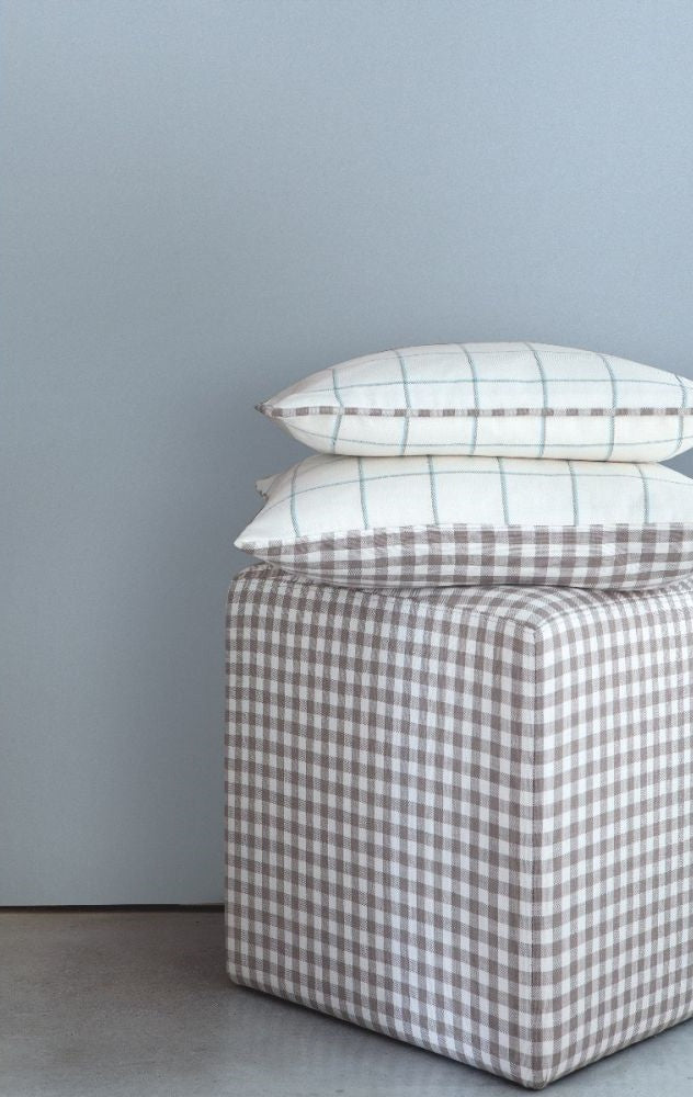 Beechwood Natural gingham check fabric used on a cube ottoman and pillows, showcasing its versatility for home décor.